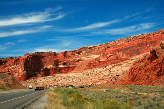 An impressive high wall of rock greet drivers as they grow near Arches National Park near Moab Utah, USA.