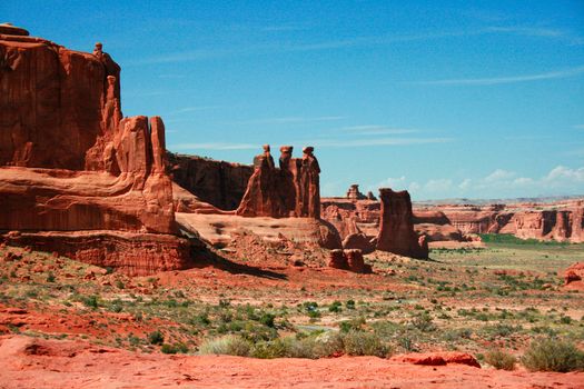 The Three Gossips is a red rock formation sculpted from Entrada Sandstone over millions of years. It is part of the Courthouse Towers complex in Arches National Park Utah, USA.