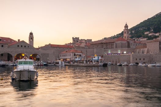 Boats moored in old town pier of Dubrovnik at sunset