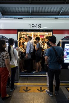 Bangkok, Thailand - January 18, 2016 : BTS skytrain full of people in the train and people waiting to go inside the train in the waiting zone at BTS Siam staion in the evening. Daily passengers of BTS skytrain is around 700,000