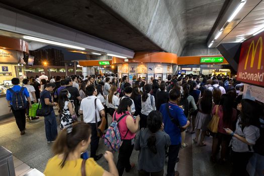 Bangkok, Thailand - January 18, 2016 : Crowd of people walking out from the BTS Mo Chit station to the road in the rush hour at night with the ticket machine in the center. Daily passengers of BTS skytrain is around 700,000