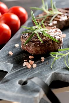 Grilled bbq steak with rosemary and tomatoes.