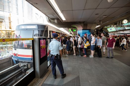 Bangkok, Thailand - January 18, 2016 : Security guard watching people to go inside the train safely at BTS Siam station in the rush hour. Daily passengers of BTS skytrain is around 700,000