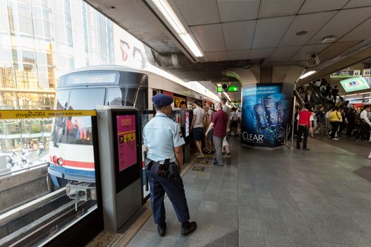 Bangkok, Thailand - January 18, 2016 : Security guard watching people to go inside the train safely at BTS Siam station in the rush hour. Daily passengers of BTS skytrain is around 700,000