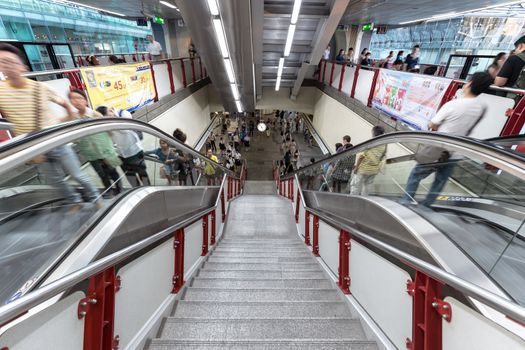 Bangkok, Thailand - January 18, 2016 : people at BTS Siam station using the escalator that has advertising along the way in the rush hour evening while nobody using the stair. Daily passengers of BTS skytrain is around 700,000