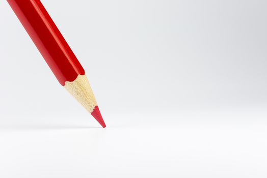 Standing red colored pencil on a white background
