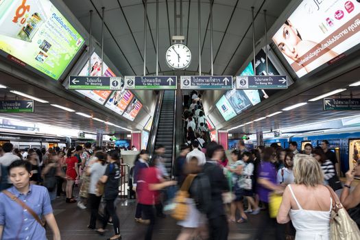 Bangkok, Thailand - January 18, 2016 : crowd of people at BTS Siam station some people waiting for the train and some people using the escalator that has advertising along the way in the rush hour evening. Daily passengers of BTS skytrain is around 700,000