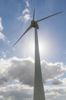 Modern windmill with against light from the Sun in the Dutch Noordoostpolder

