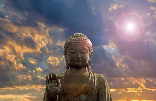 Tian Tan World Largest Sitting Bronze Buddha at Ngong Ping Village in Hong Kong with Clouds and Sun Flare Background