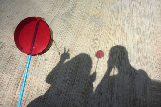 Silhouette of couple playing asian hand drum toy