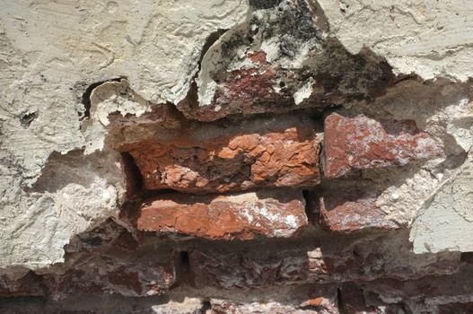 Broken brick in white wall