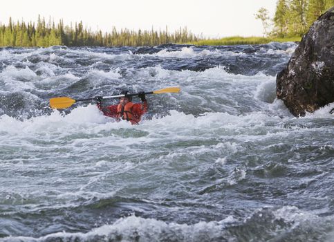 Kayaker turning over in the cataract whitewater