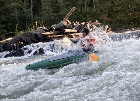 Kayaker in the  whitewater of a river Umba in Russia