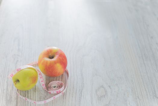 Apples in the measuring tape on the wood background