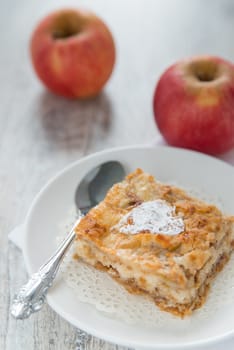 Piece of an apple pie and two apples