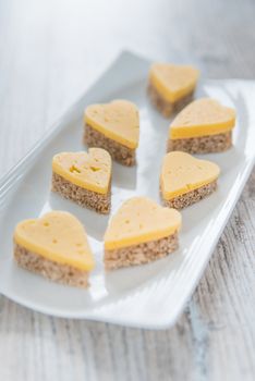Heart shaped cheese sandwiches on the white plate