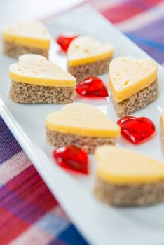 Heart shaped cheese sandwiches on the white plate