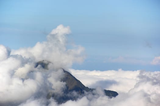 Landscape high mountain peaks covered with clouds