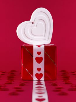 white shape heart over gift box on red background