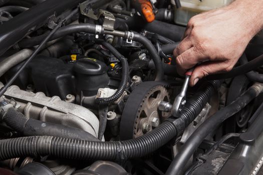 Close-up Of Hand Repairing Car Engine