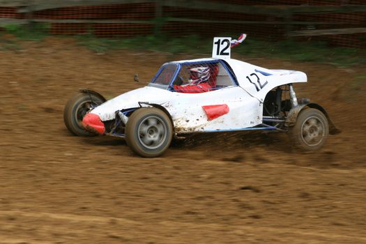 Buggy on track going fast and throwing dirt in the air