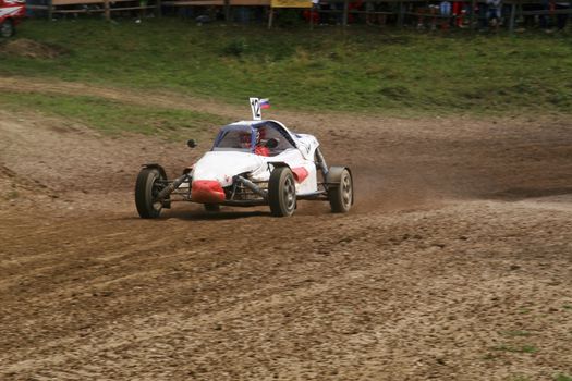 Buggy on track going fast and throwing dirt in the air