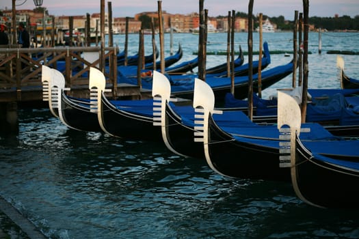 Gondolas floating on the water with Venice in the background.
