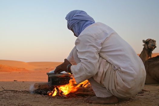 Native arab bedouin making a dinner in middle of the desert in Egypt