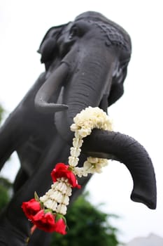Elephant at a buddhist temple with rosary on a trunk