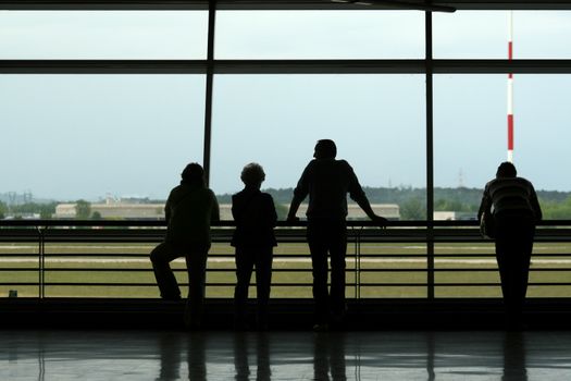 Silhouetts of people waiting at the airport
