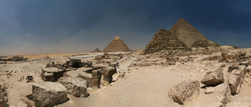 Giza plateau - with all three big pyramids (the darker one close to the centre is small pyramid for a queen) and a Sphinx on the left. The picture was made from 17 horizontal pictures from Canon 20D in two lines