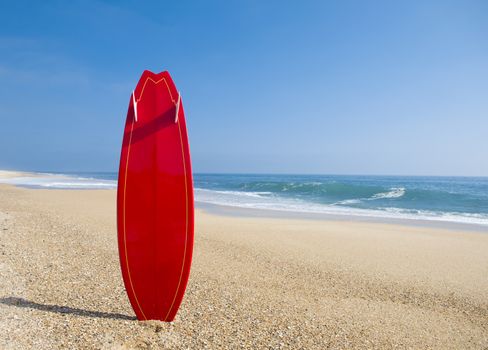 Beach landscape with a red surfboard on the sand