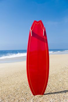Beach landscape with a red surfboard on the sand