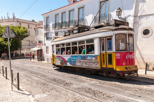 LISBON, PORTUGAL - AUGUST 23: Famous Lisbon tram number 28 on the street of Alfama district on 23 August, 2014 in Lisbon. Trams keep the traditional style of the historic center of Lisbon.