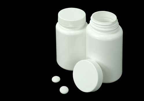 two white pills with two white jar on a black background