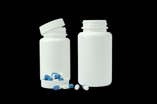 some pills of a white and blue colors with two white jar on a black background
