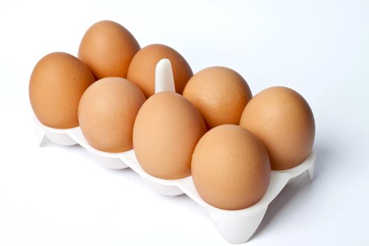 8 eggs in a box on a light background