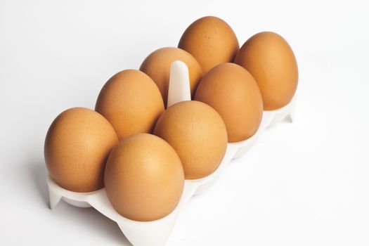 8 eggs in a box on a light background