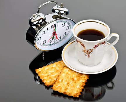 cup of coffee and watch the table on a dark background