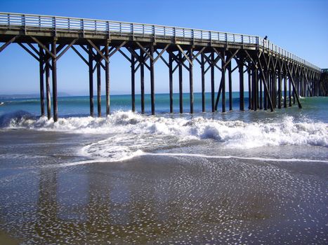 Man watches ocean on pier in California coast