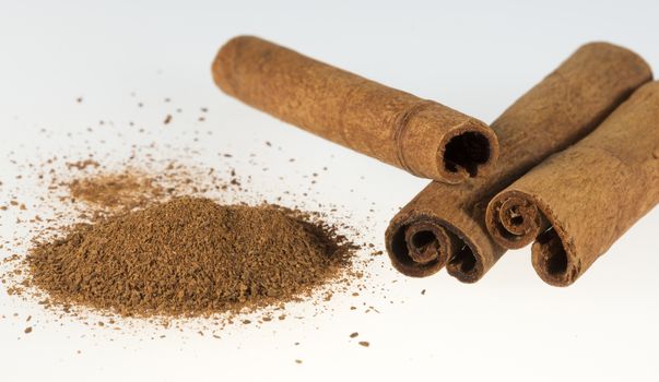 Cinnamon Sticks and Powder close up on white background.