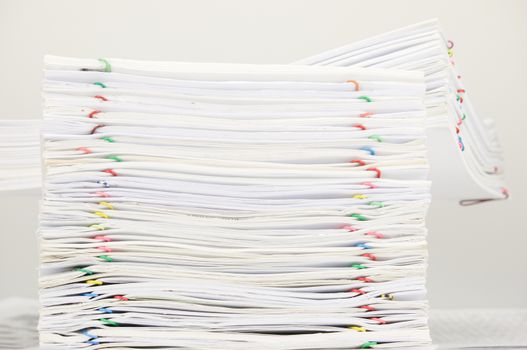 Pile of document with colorful paper clip on finance account place on white table.