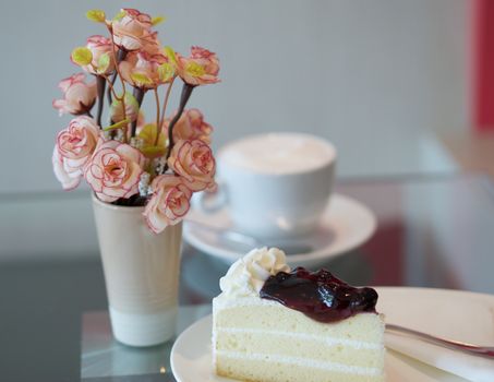 Blueberry cake with cup of coffee on table at restaurant.