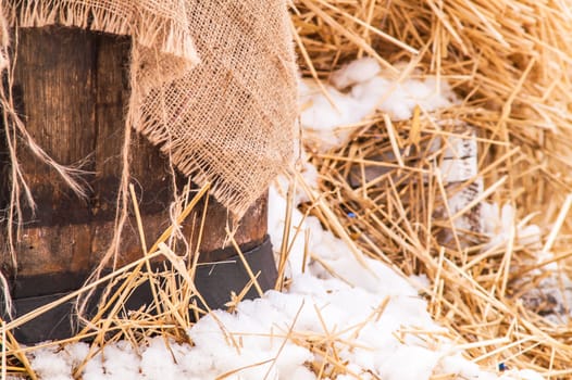 wooden barrel near the straw on the snow