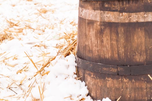 wooden barrel near the straw on the snow