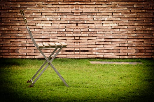 Old chair in vintage light on brick wall background