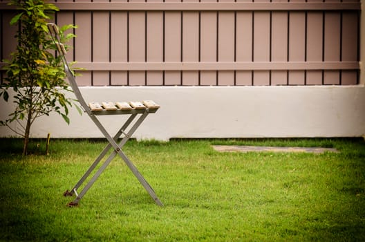 Old chair on green grass in vintage light