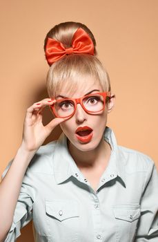 Beauty fashion portrait woman in stylish glasses surprised. Attractive pretty blonde sexy hipster girl. Confidence, success, Pinup hairstyle, trendy red bow.Unusual playful, creative. Vintage, vanilla