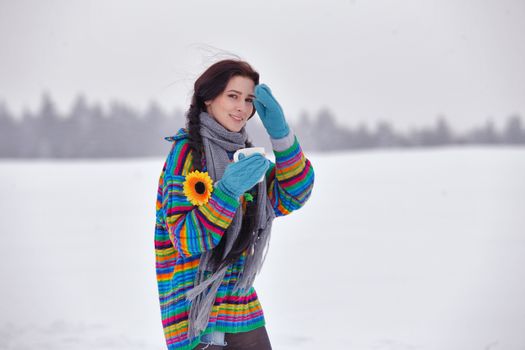 Beautiful girl in a sweater on a winter walk with a cup of coffee