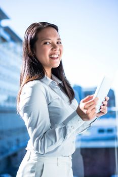 Smiling businesswoman using tablet outdoors